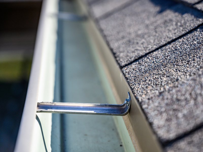 view inside roof gutter with clips and edge of shingles