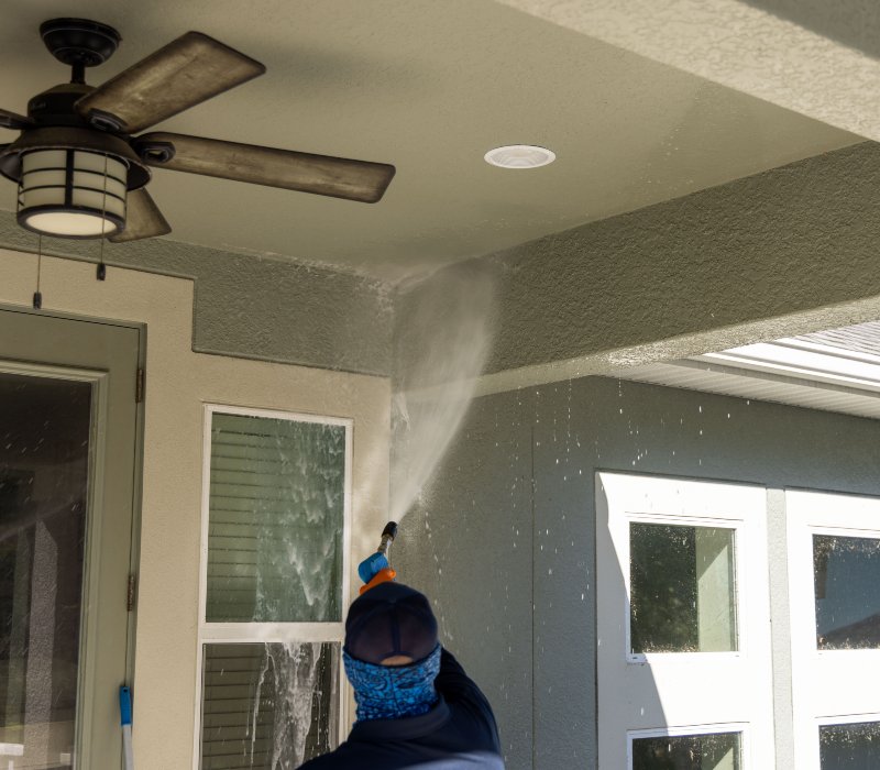 a pressure washing machine spraying water onto the interior wall of a house during a cleaning process