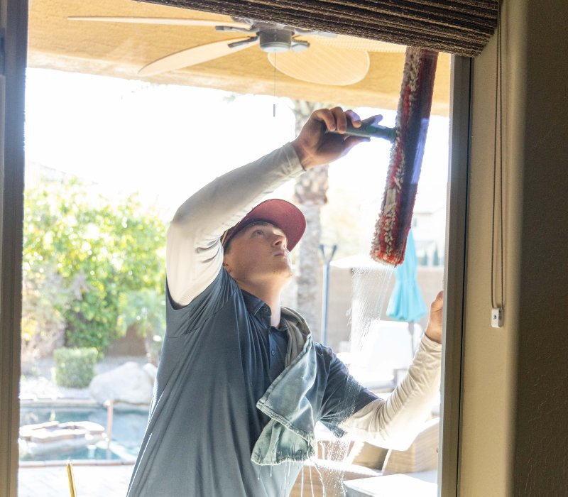 A person cleaning a window with a squeegee