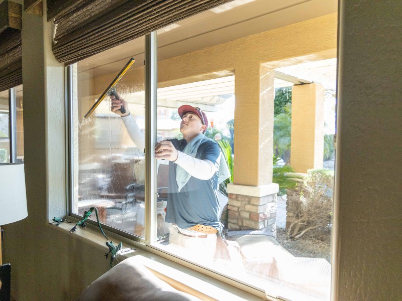 A professional window cleaner cleaning the window glass