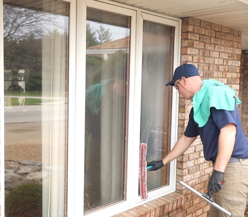 A man cleaning a home window.